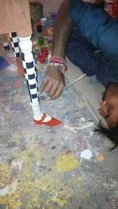 L'artiste peaufine son oeuvre, les escarpins roses et les collants à damiers qui supporteront l'excentrique table de nuit....